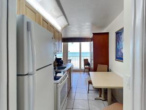 cocina con nevera blanca y mesa con mesa en Harbour Beach Resort 603, en Seabreeze 29 fotos más