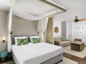 a bedroom with a large white bed and a couch at Mövenpick Balaland Resort Lake Balaton in Szántód +159 photos