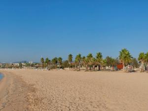 a sandy beach with palm trees in the distance at Mercure Thalasso & Spa Port Fréjus in Fréjus