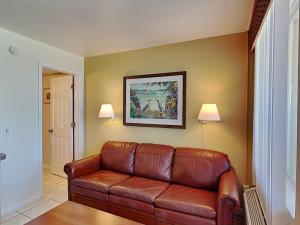 a living room with a brown leather couch at Harbour Beach Resort 503 in Daytona Beach