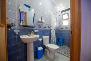 a blue tiled bathroom with a toilet and a sink at Dar Boukhari Luxury Stay in Chefchaouene +39 photos