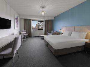 Pokój hotelowy z dużym białym łóżkiem i krzesłami w obiekcie Mantra Melbourne Melton w mieście Melton +25 zdjęć