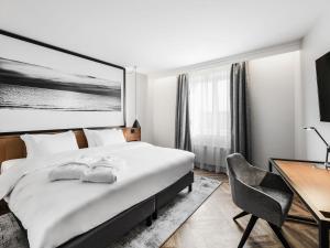 a hotel room with a bed and a desk at MERCURE KLAIPEDA CITY HOTEL, Meetings, Events, Restaurant & Bar - Accor Group, Pet Stay FREE in Klaipėda