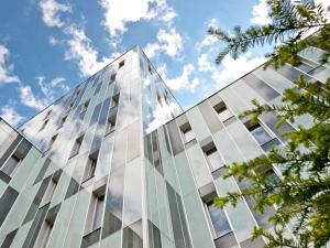 a glass building with a blue sky in the background at Mercure Hotel Hamburg Mitte in Hamburg