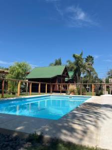 a swimming pool in front of a house at Cabaña con pileta & jardín- a minutos del centro y la playa in Miramar