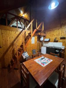 a dining room with a wooden table and stairs at Cabaña con pileta & jardín- a minutos del centro y la playa in Miramar