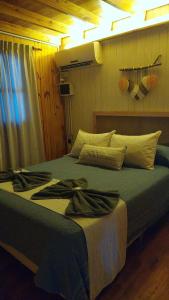 a bedroom with a large bed with a blue blanket at Cabaña con pileta & jardín- a minutos del centro y la playa in Miramar +3 photos