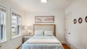 シアトルにあるCharming Downtown Seattle Condo Steps from Iconic Sights!の白いベッドルーム(ベッド1台、窓2つ付)