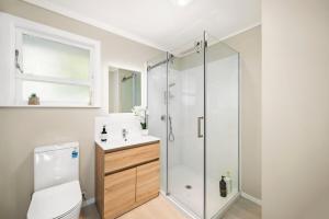 a bathroom with a shower and a toilet and a sink at 5 Bedrooms Lake View Cosy Place in Rotorua +19 photos