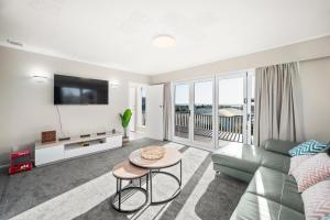 a living room with a couch and a table at 5 Bedrooms Lake View Cosy Place in Rotorua