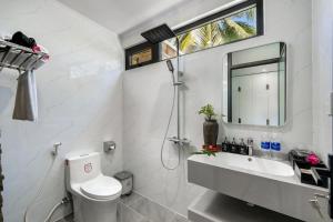une salle de bain avec toilettes, lavabo et miroir dans l'établissement Coastal Heaven villa,5' walk beach, pacefull villa, à Hà Bàng