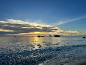 un coucher de soleil sur l'océan avec des bateaux dans l'eau dans l'établissement Coastal Heaven villa,5' walk beach, pacefull villa, à Hà Bàng