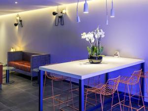 a room with a table with a vase of flowers on it at Mercure Paris Malakoff Parc des Expositions in Malakoff