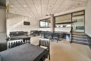 Un restaurante con mesas y sillas y una pared de ladrillos. en Capital O Amit Palace, en Bhīlwāra 32 fotos más