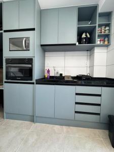 a kitchen with white cabinets and a microwave at Apartamento na Praia dos Carneiros a 250m do mar in Tamandaré +26 photos