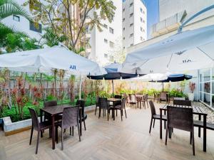 a patio with tables and chairs and umbrellas at ibis budget Sao Paulo Jardins in Sao Paulo