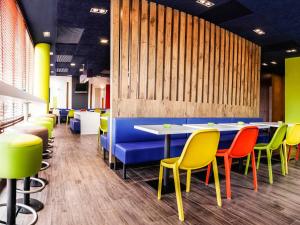 a dining room with colorful chairs and tables at Ibis Budget Barcelona Sant Andreu De La Barca in Sant Andreu de la Barca