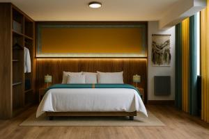 1 dormitorio con 1 cama grande y pared amarilla en Hanaqua Hotel, en Cusco