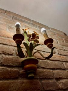 a light on a brick wall with a flower in a vase at Casa Experience - Venas Di Cadore in Venas +35 photos