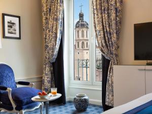 a room with a window with a view of the building at Le Royal Hotel Lyon - MGallery Collection in Lyon