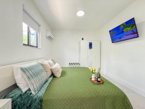 a bedroom with a bed with a green blanket at Luxury Suite Studio With Kitchen & Spa Shower in Lake Lucerne