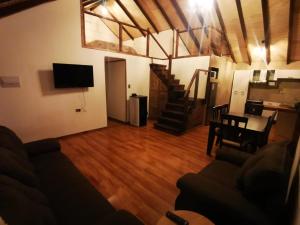 a living room with a couch and a table and stairs at Cabaña monte rio in Cabo Juan Roman