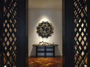 una habitación con una mesa con una escultura en la pared en Mövenpick Hotel Sukhumvit 15 Bangkok, en Bangkok
