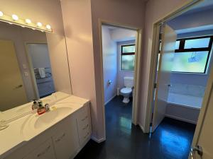 a bathroom with a sink and a toilet and a mirror at 4 St James Avenue in Hanmer Springs +8 photos