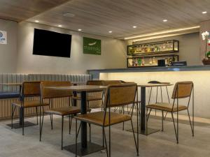 restauracja ze stołami i krzesłami oraz barem w obiekcie Mercure Maceio Pajuçara w mieście Maceió