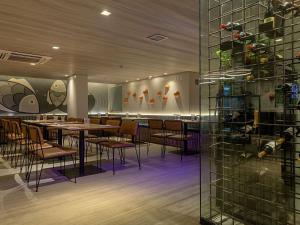 restauracja ze stołami i krzesłami oraz szklaną ścianą w obiekcie Mercure Maceio Pajuçara w mieście Maceió