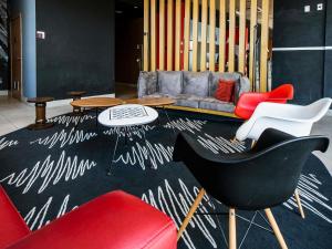 a living room with red chairs and a couch at Ibis Guaratingueta Aparecida - Circuito da Fé in Guaratinguetá