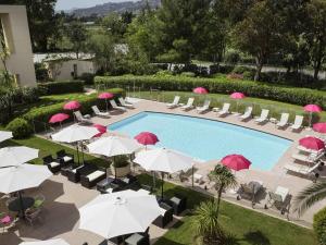an overhead view of a pool with umbrellas and chairs at Mercure Cannes Mandelieu in Cannes