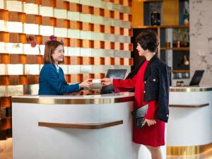 two women are standing at a counter in a store at Mövenpick Living West Hanoi in Hanoi +177 photos