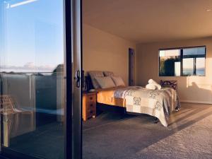 a bedroom with a bed and a sliding glass door at Auckland Sunrise Sea View in Auckland