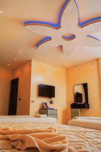カイロにある3 PYRAMiDS HUT HOTELのベッドルーム1室(ベッド2台、天井テレビ付)