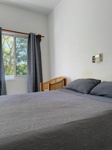 Un dormitorio con una cama grande y una ventana. en Punta Sol, en Brisas de Zicatela