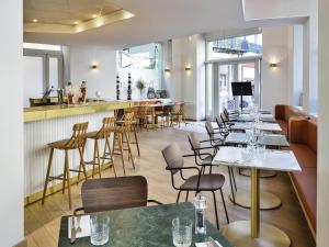 a restaurant with tables and chairs and a bar at Mercure Marseille Canebière Vieux-Port in Marseille