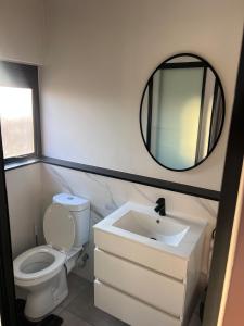 Un baño con inodoro, lavabo y espejo. en Crystal ace lagoon, en Midrand 10 fotos más