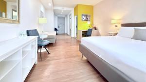ナポリにあるPrestige Rooms Chiaiaの大きな白いベッドと机のある寝室