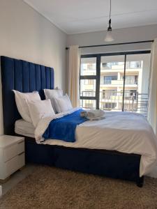 Una cama grande con cabecera azul en un dormitorio. en Crystal ace lagoon, en Midrand