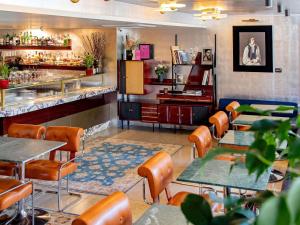 a restaurant with tables and chairs and a bar at MUZE Hotel Dusseldorf - Handwritten Collection in Düsseldorf