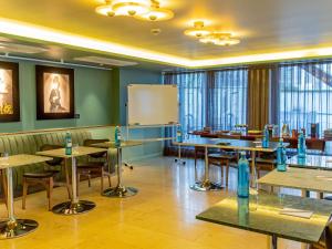 a classroom with tables and chairs and a whiteboard at MUZE Hotel Dusseldorf - Handwritten Collection in Düsseldorf