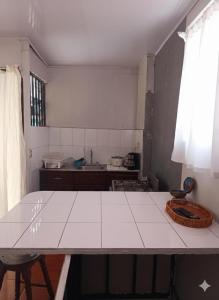 a kitchen with a white counter top and a table at Nómadas del Pacífico in Tapantí