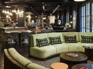 ル・テュケ・パリ・プラージュにあるMercure Hôtel Le Touquetのソファとテーブルと椅子のあるリビングルーム