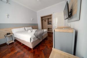a bedroom with a bed and a television in it at HOTEL REGIS in Buenos Aires