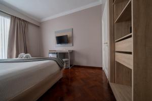 a bedroom with a bed and a tv and a closet at HOTEL REGIS in Buenos Aires +46 photos