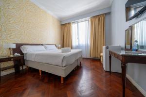 a hotel room with a bed and a desk at HOTEL REGIS in Buenos Aires