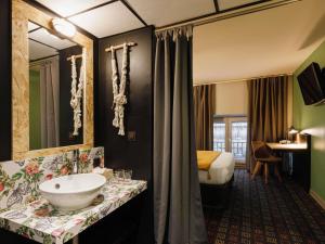 a bathroom with a sink and a bed in a room at Greet Hotel Lyon Confluence in Lyon