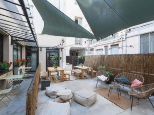 a patio with chairs and tables and a fence at Greet Hotel Lyon Confluence in Lyon