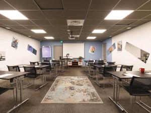 an empty classroom with tables and chairs and a whiteboard at Greet Hotel Lyon Confluence in Lyon